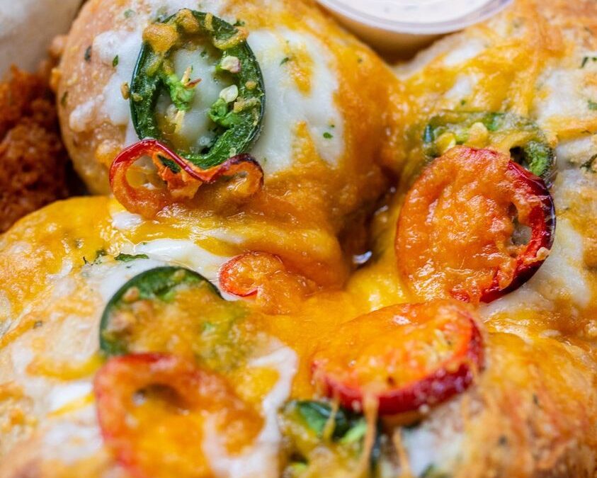 Close-up of a cheesy dish with sliced peppers